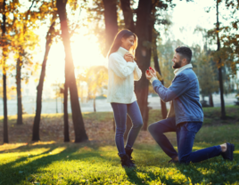 Man proposing to woman in middle of field