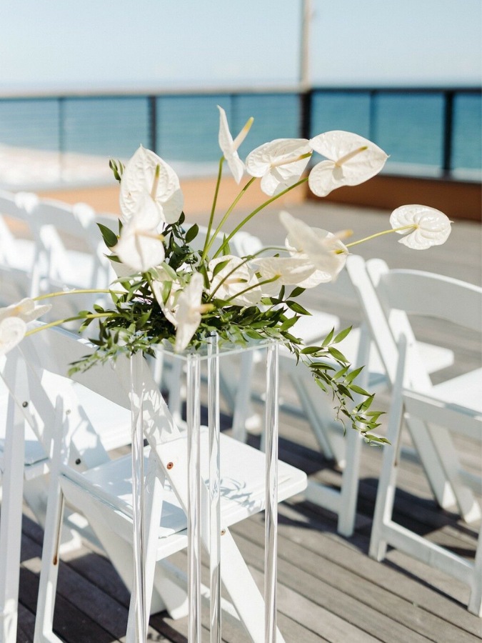 anthurium floral arrangement on pedestal at oceanside wedding ceremony