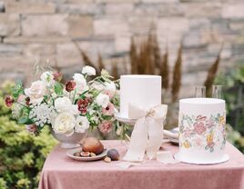 wedding cake table with two white fondant cakes and flower centerpiece 