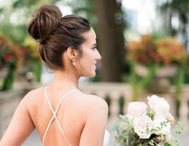 Bride wears her hair in an elegant top knot. 