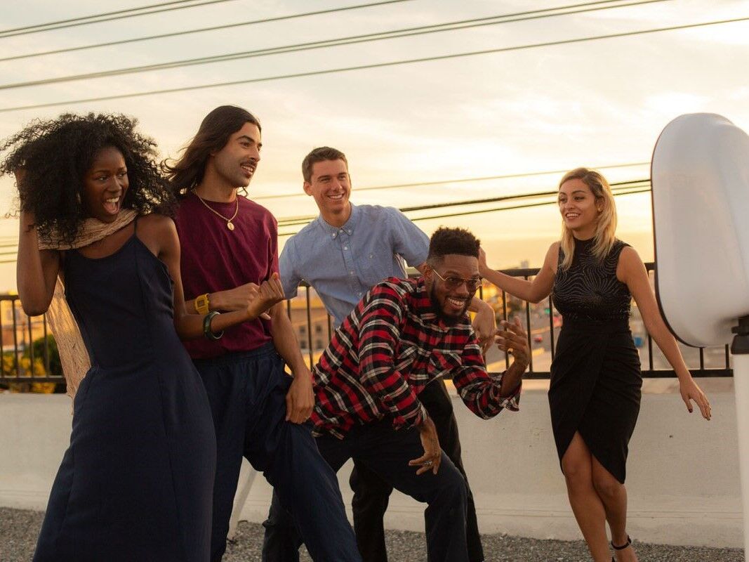 Guests dancing on the rooftop patio in front of a photo booth
