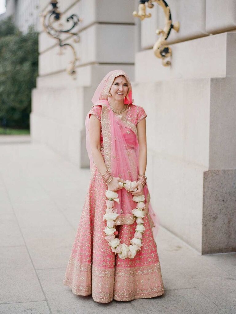 Bride wearing light pink and gold lehenga and saree