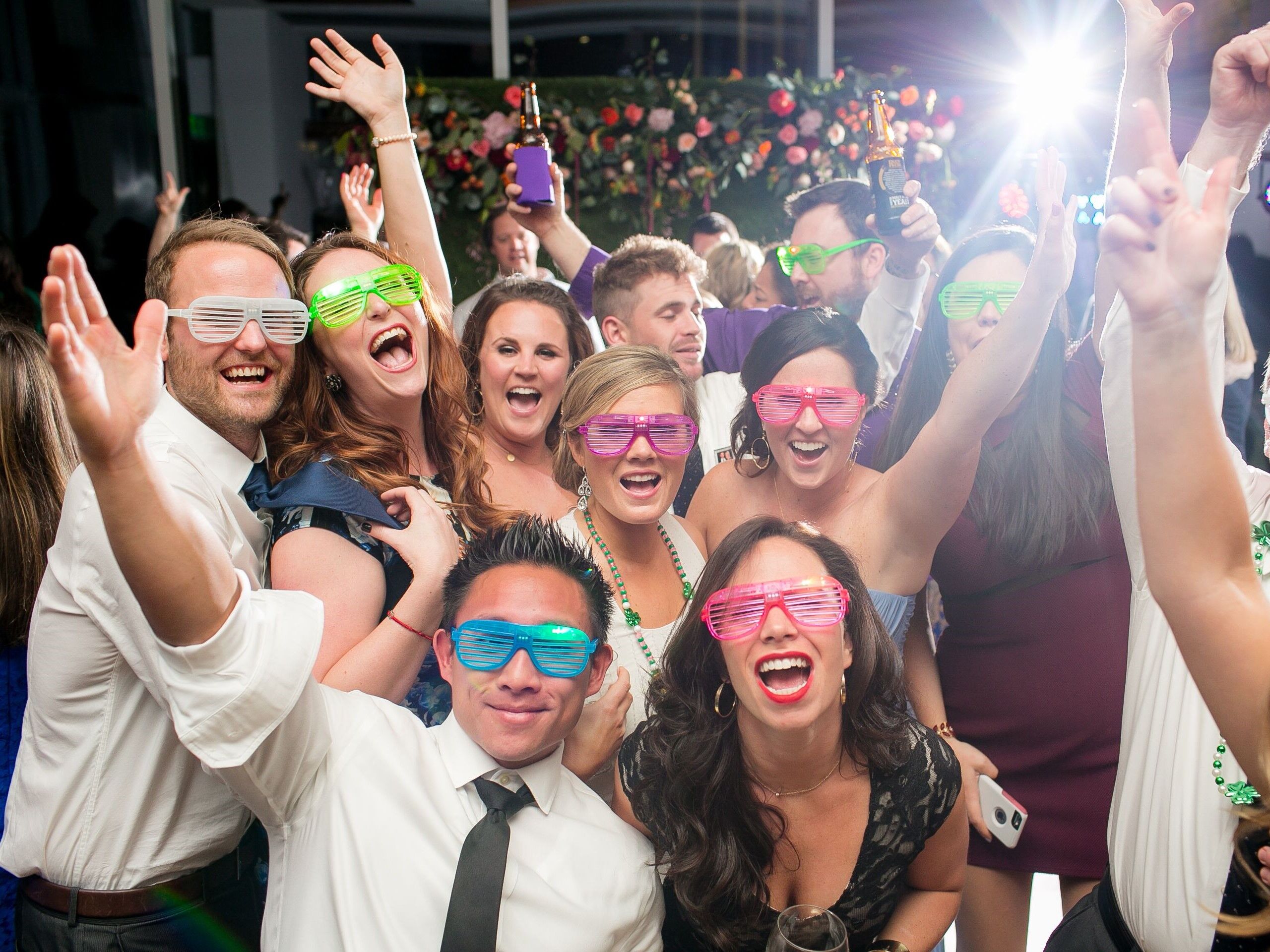 Wedding party posing for a funny picture wearing colorful glasses
