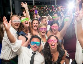 Wedding party posing for a funny picture wearing colorful glasses