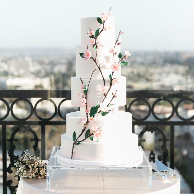Modern white wedding cake with cherry blossom decorations