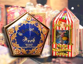 Chocolate Frogs in elegant pentagon purple container with gilded gold details and Every Flavor Beans in circus-themed packaging