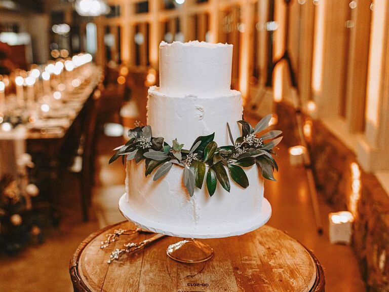 Simple rustic wedding cake with white icing and garland of eucalyptus leaves