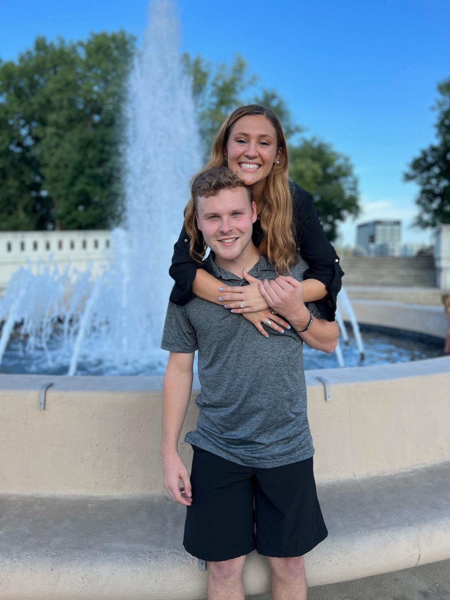 On August 27th of 2022, Eli and Liz celebrated their 3 year anniversary and their everlasting love. Eli planned a very elaborate date with dinner reservations and told Liz they had to open her gift at the fountain that they had their first date at. Liz thought this was super special but did not necessarily think anything of it. As Eli and Liz began opening gifts at the fountain, Eli had 
instructed Liz to open one gift before the other. The first gift was a glass plaque that had a map of west lafayette and had a heart on the spot where they knew they found the one. Next, Eli had Liz open her second gift, a card which her instructed her to read out loud. Before Liz could reach the bottom of the card she knew what was going to be asked and looked up to see the love of her life asking her to Marry him. She of course said yes and they celebrated with drinks and dinner at their favorite restaurant, East end. 