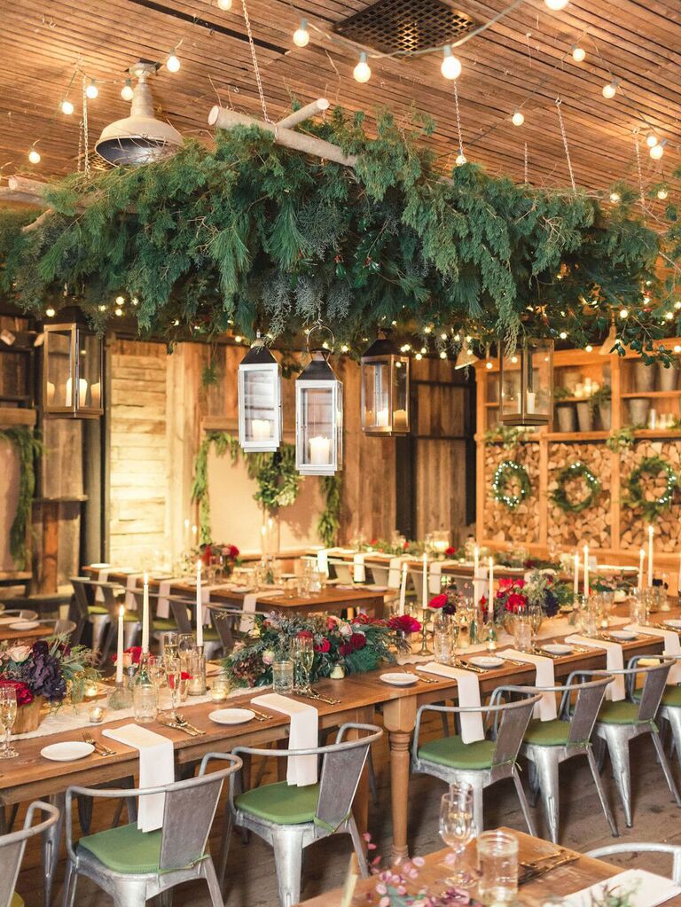 Suspended winter wreath and pine branches at holiday-themed wedding reception