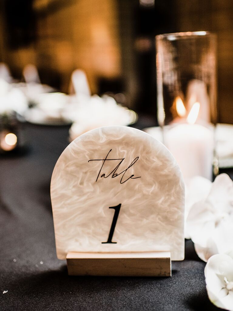 rounded acrylic wedding table number with marbled beige and white iridescent design