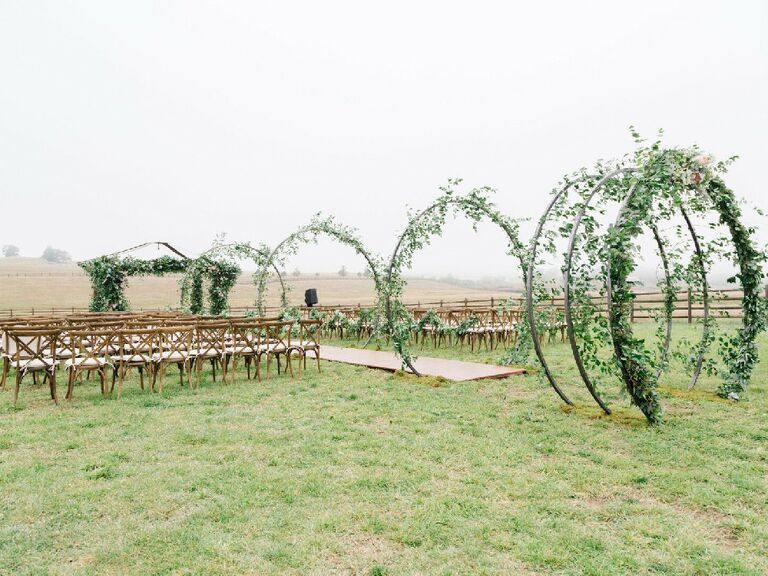 Steel hoops covered in eucalyptus and smilax along ceremony aisle