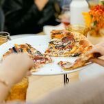 Guests eating pizza at rehearsal dinner