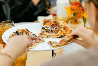 Guests eating pizza at rehearsal dinner