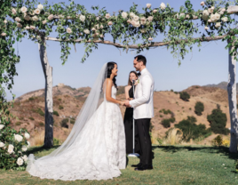 Couple holding hands at altar while officiant does wedding reading