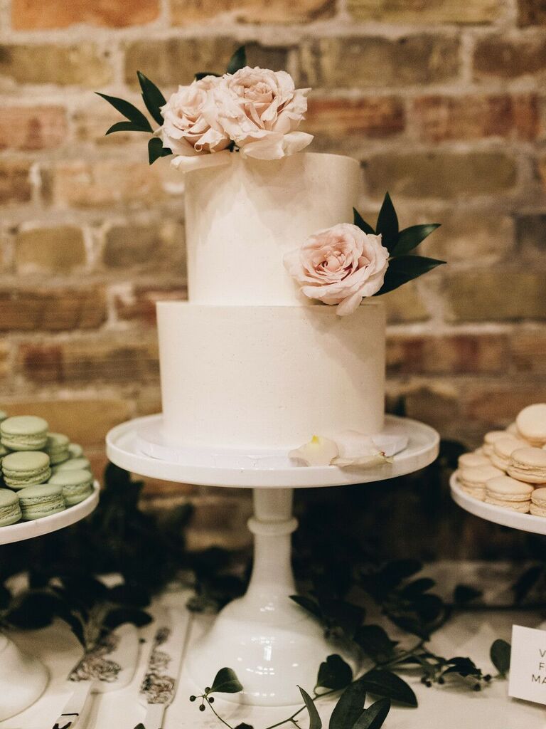 two tier wedding cake with smooth buttercream icing and blush pink roses