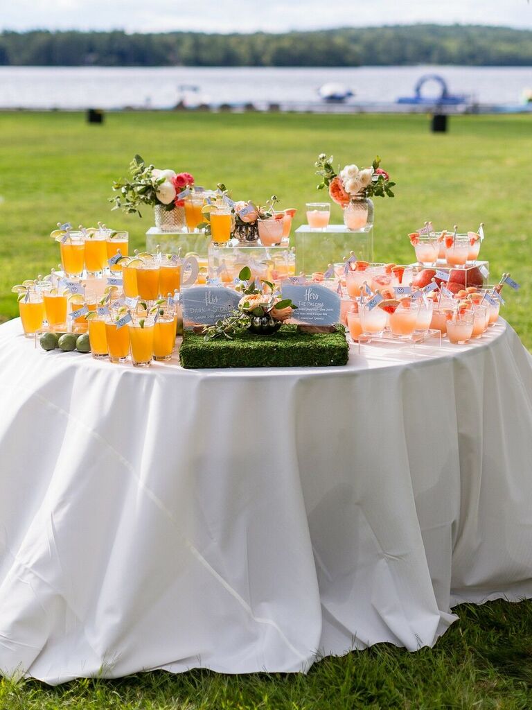 outdoor wedding drink station idea with two groups of signature cocktails on table