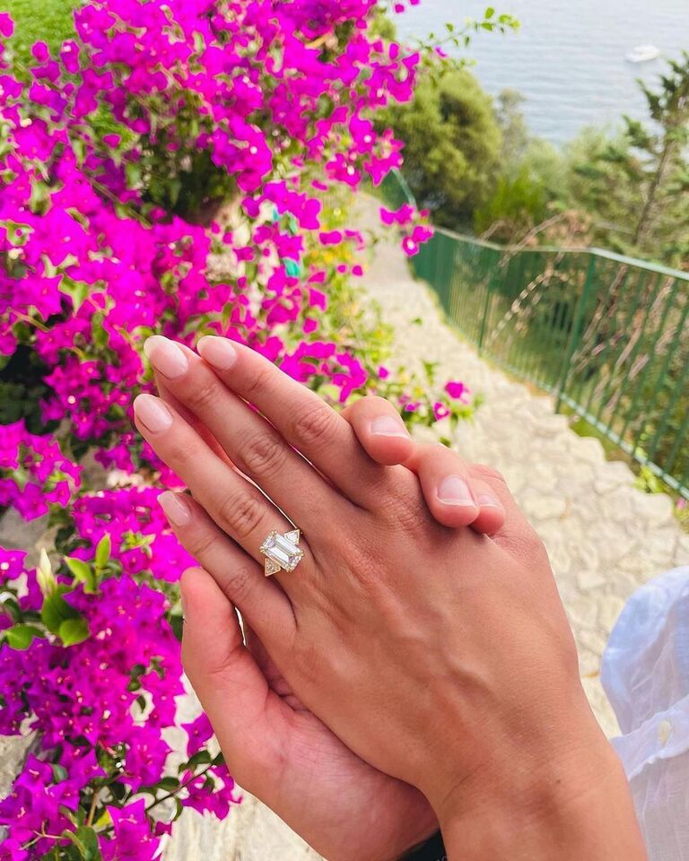 Engagement ring selfie above pink flowers