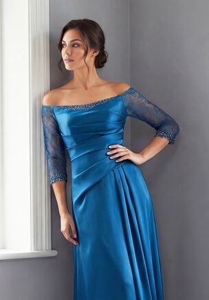 This Marquis Satin fit-and-flare gown with lace is an elegant and refined choice for the Mother of the Bride. The portrait neckline and 3/4 sleeves are finished with delicate beaded trim at the neckline and sleeve edges, adding a touch of sparkle. The gathered bodice shapes beautifully through the hips, softly transitioning into gentle gathers at the front of the skirt for graceful movement. Timeless, sophisticated, and flattering, this gown combines classic elegance with subtle, modern detailing.