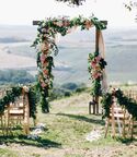 Altar at outdoor wedding ceremony with floral arch