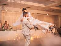 Husband spinning around his bride on the dance floor
