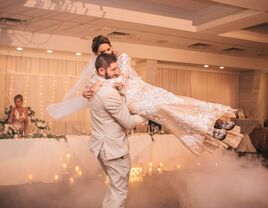 Husband spinning around his bride on the dance floor