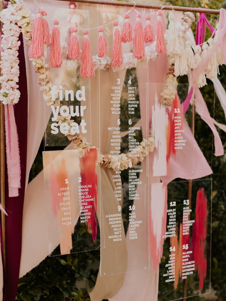 Acrylic seating chart hanging amongst boho pink decorations