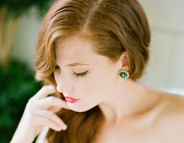 Auburn hair bride portrai with emerald earrings and red lipstick