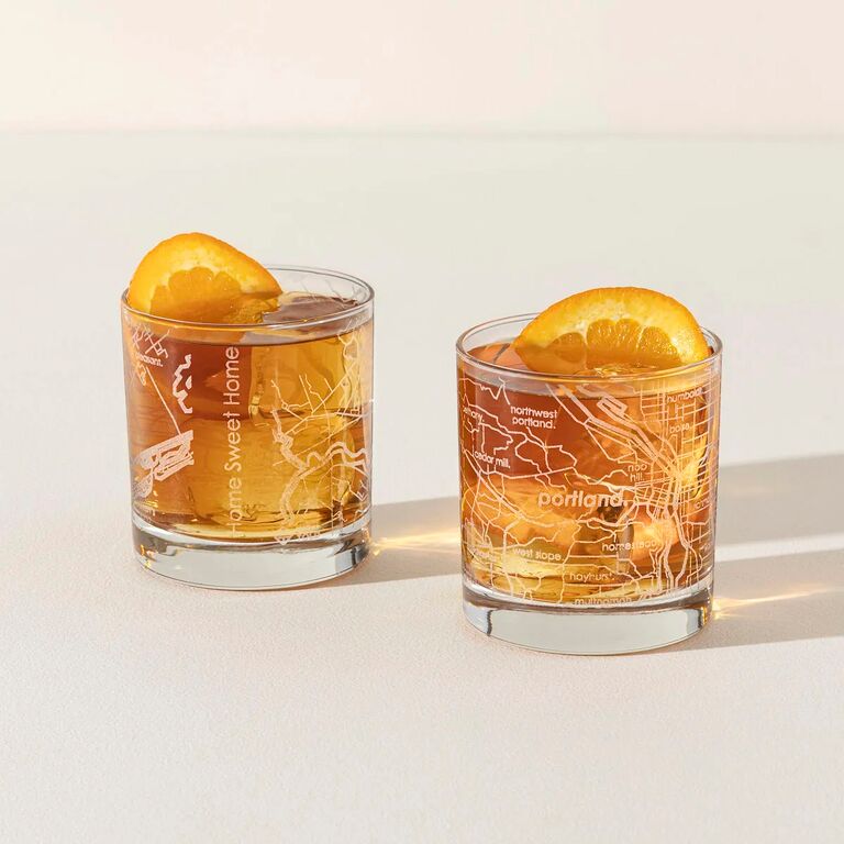 Two cocktail glasses featuring customized hometown maps. 