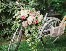 vintage blue bike decorated with hydrangeas, pink roses and greenery