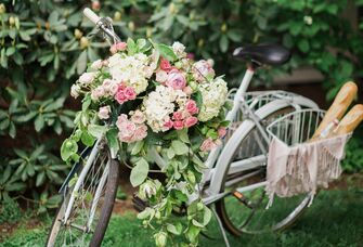 vintage blue bike decorated with hydrangeas, pink roses and greenery