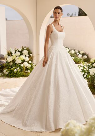 Princess silhouette wedding dress in Jasmine brocade with square neckline with straps and back with round opening. Smooth finish.