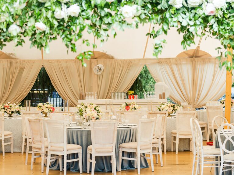 classic wedding reception with round tables and white cane back chairs
