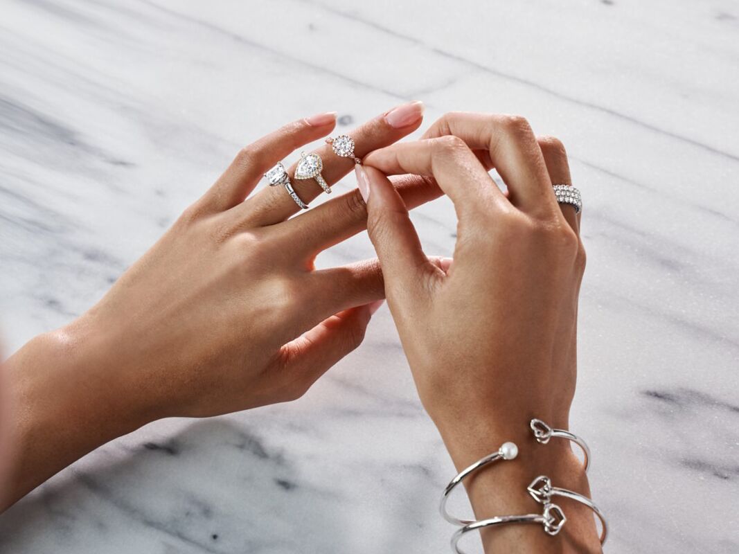 Woman trying on three different engagement rings