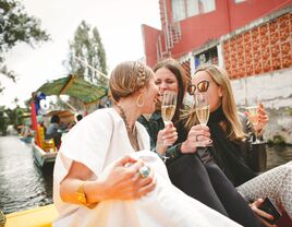 Three women enjoying champagne on a boat for bachelorette party