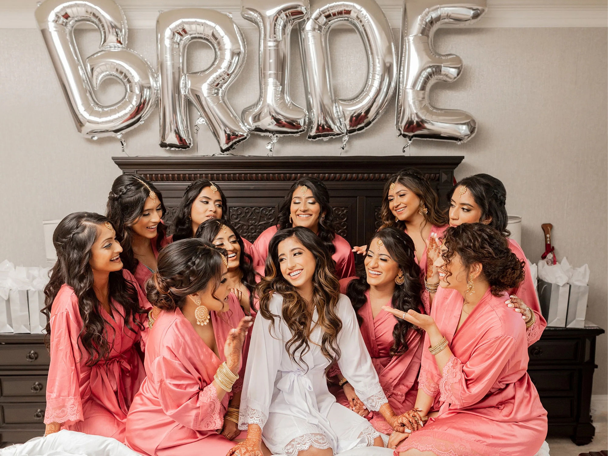 Bride with bridal party wearing pink bridesmaid robes