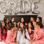 Bride with bridal party wearing pink bridesmaid robes