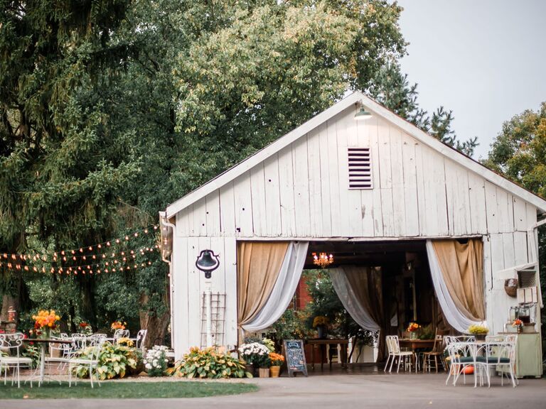 Barn wedding venue with draped fabric over entrance and string lights