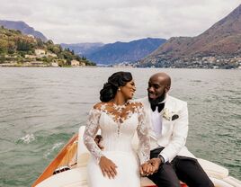 The happy couple share a moment together on a boat in the middle of a lake