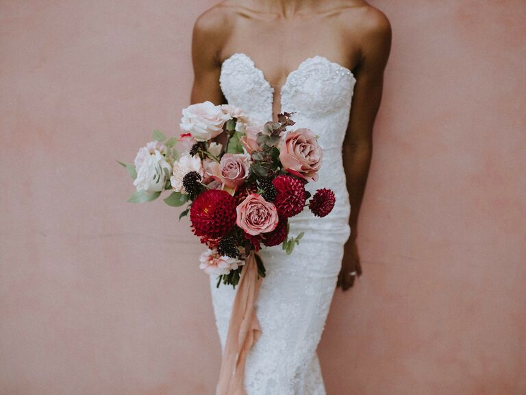 bride wearing strapless sweetheart gown holds wedding bouquet