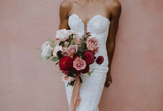 bride wearing strapless sweetheart gown holds wedding bouquet