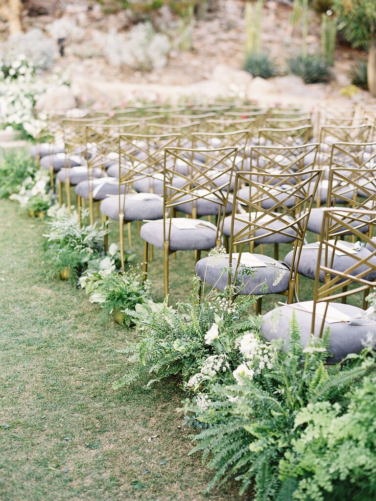 modern outdoor wedding ceremony venue with gold chameleon chairs and fern aisle markers in gold vases