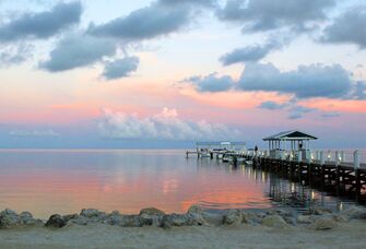 Dock on the water at sunset