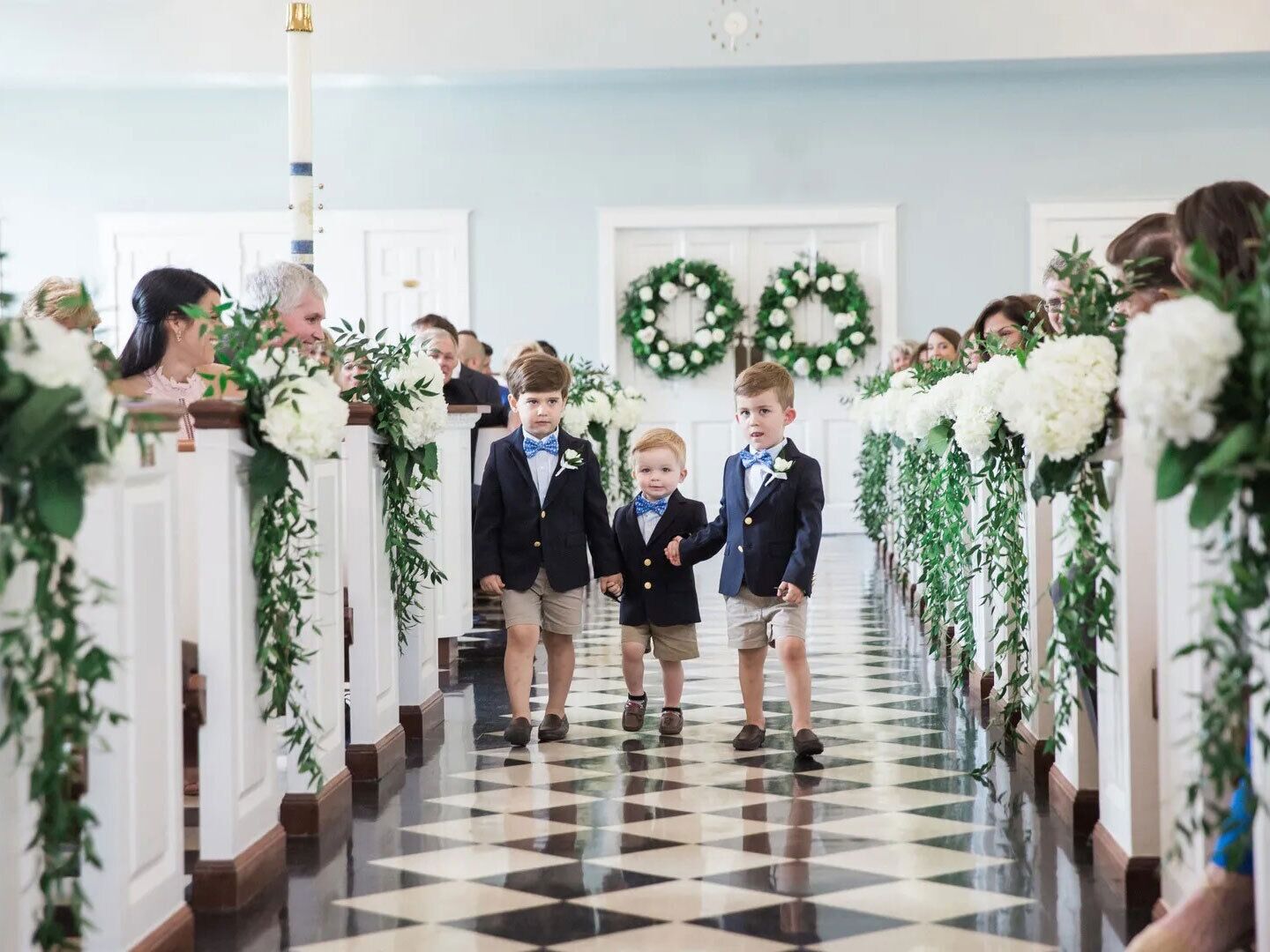 Ring bearers smiling and walking down the aisle.