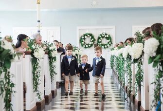 Ring bearers smiling and walking down the aisle.