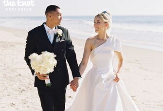 Michael Norman and wife Jenna Adams holding hands on their wedding day