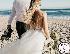 Bride and groom walking on beach on wedding day