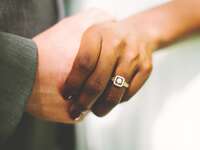 couple holding hands with engagement ring