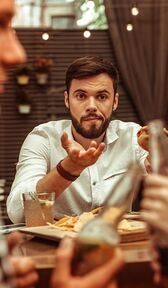 man trying to speak to couple who is engrossed in their own conversation