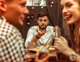 man trying to speak to couple who is engrossed in their own conversation