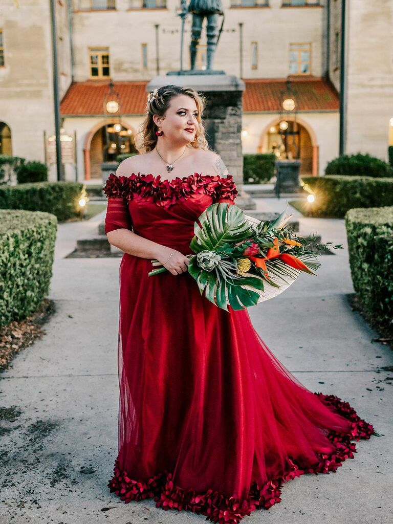 Bride wearing red off the shoulder wedding dress with floral appliques